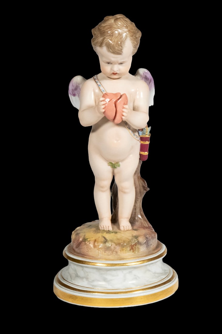MEISSEN PORCELAIN FIGURE OF CUPID WITH BROKEN HEART: A Meissen figure of Cupid depicted standing with wings and quiver, holding a broken heart. Set against a tree stump and raised on a faux marble and gilt base. Blue underglaze crossed swords mark, inci