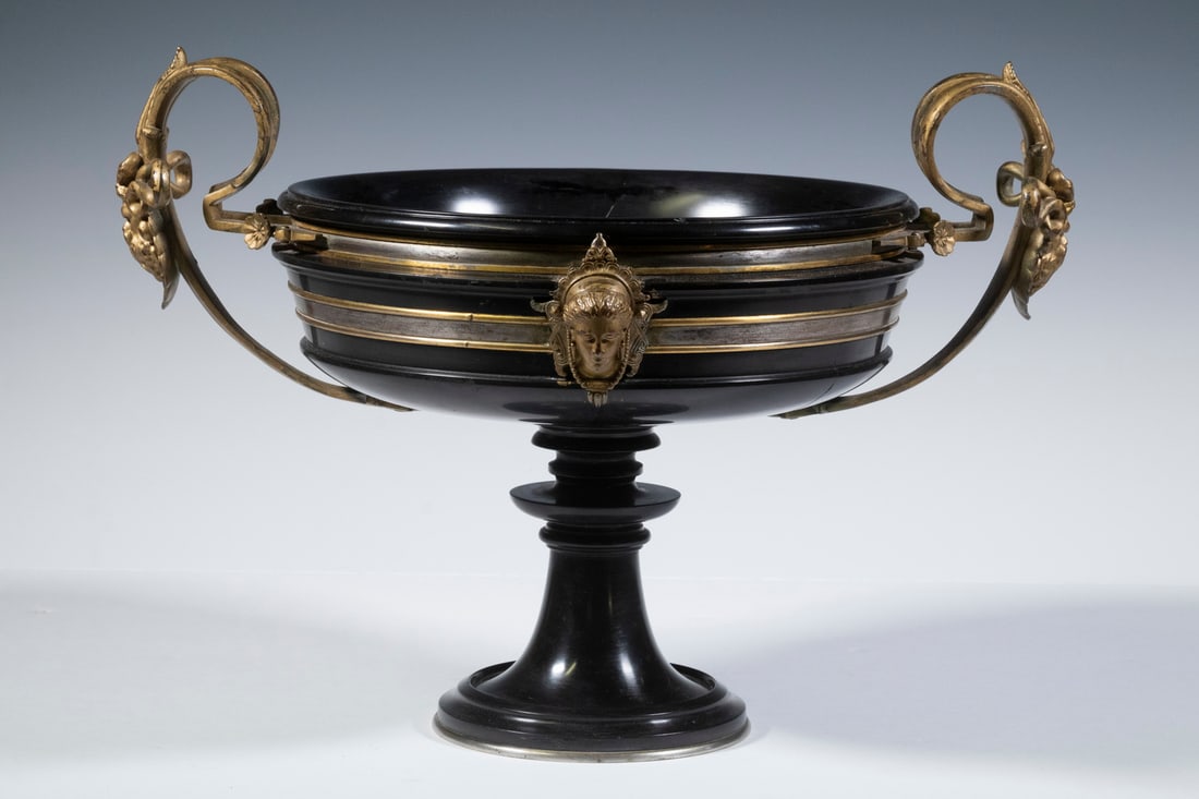 FERDINAND BARBEDIENNE (FRANCE, 1810-1892): Romanesque style, well proportioned lathe-turned slate shallow footed bowl having gilt bronze and silver banding (marked F. Barbedienne) with Minerva head lugs and looped leafy Bacchus head handles, l