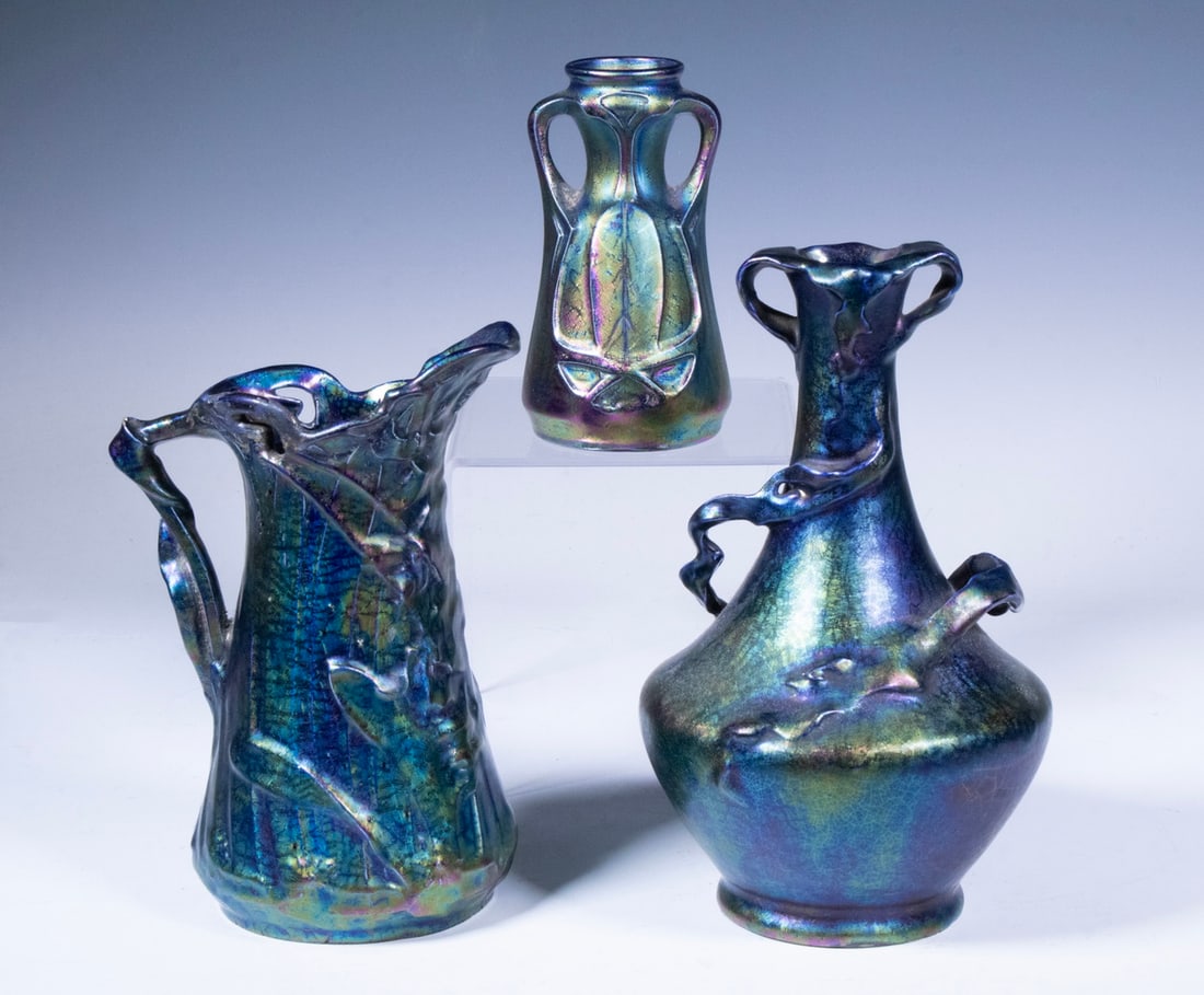 (3) AUSTRIAN IRIDESCENT ART NOUVEAU POTTERY VASES: (3) AUSTRIAN IRIDESCENT ART NOUVEAU POTTERY VASESEach vase features Art Nouveau-inspired forms with sinuous handles and raised organic motifs, finished in lustrous iridescent glazes in blue, green, an