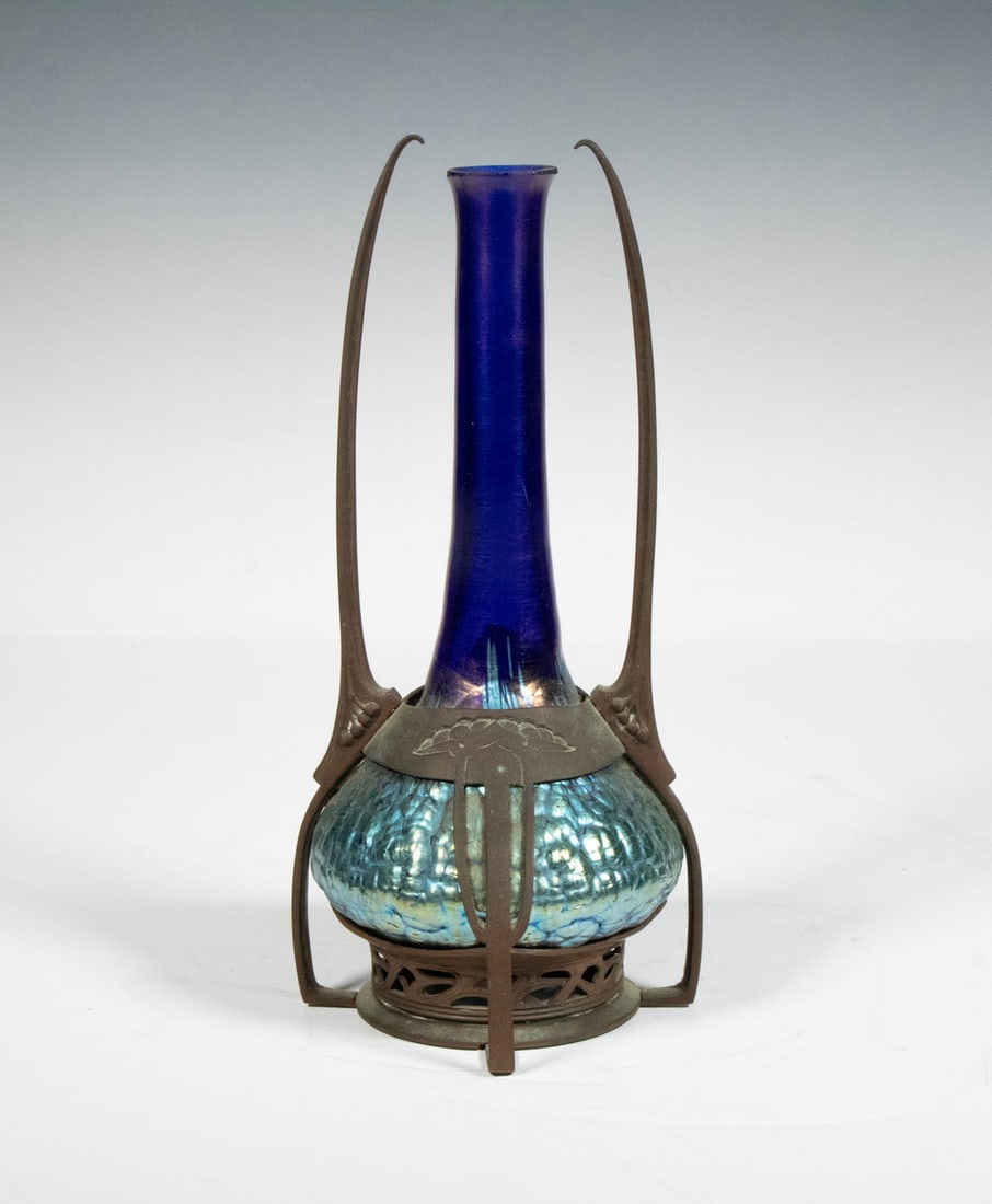 LOETZ IRIDESCENT ART GLASS VASE IN JUGENDSTIL METAL MOUNT, C. 1900: LOETZ IRIDESCENT ART GLASS VASE IN JUGENDSTIL METAL MOUNT, C. 1900A tall iridescent glass vase with crackle-textured lower body in vibrant blue and green hues, surmounted by a long cobalt neck. Set in