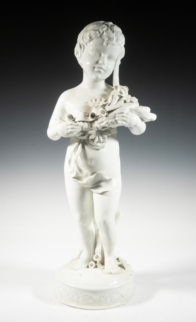 LARGE ITALIAN CERAMIC PUTTI SCULPTURE: LARGE ITALIAN CERAMIC PUTTI SCULPTUREVintage White Glazed Standing Figurine, holding a ribbon tied bundle of flowers and grains, atop an integral round base, with painted mark "100/B, Italy" on base.