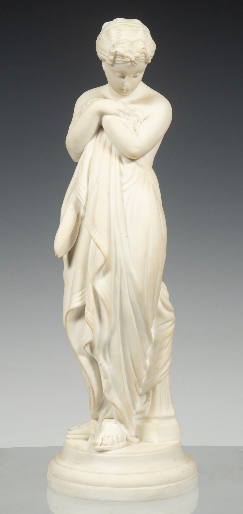 PARIAN FIGURE OF STANDING WOMAN: PARIAN FIGURE OF STANDING WOMANPorcelain Figure of a standing Classical woman, likely depicting the virtue of modesty, with incised "A" on the base.10 x 3 1/4 in. (25.4 x 8.3 cm.)