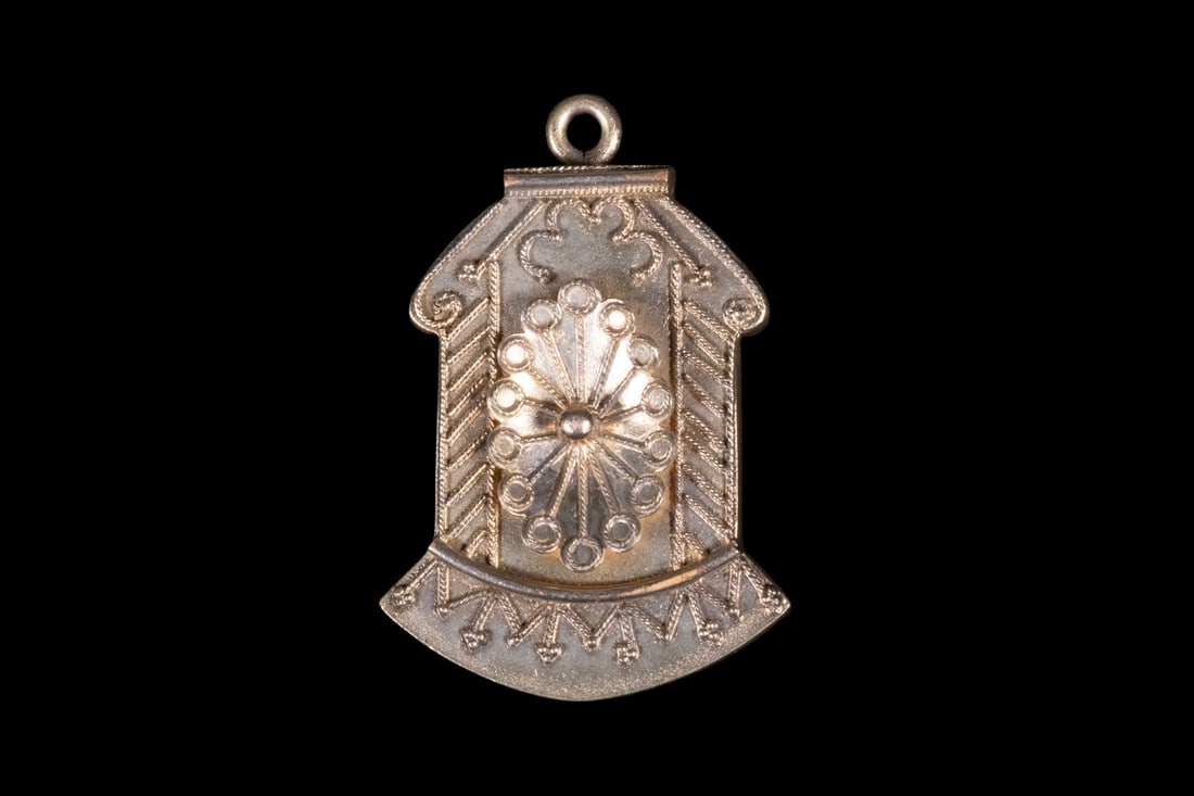 VICTORIAN GOLD-FILLED LOCKET: VICTORIAN GOLD-FILLED LOCKETA hinged gold-filled locket of shaped form, with decorative exterior detailing and a suspended bail at the top. The locket opens to reveal an interior compartment originall