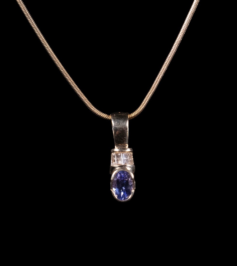 14K GOLD TANZANITE AND DIAMOND PENDANT WITH CHAIN: 14K GOLD TANZANITE AND DIAMOND PENDANT WITH CHAINA 14K yellow gold pendant set with an oval-cut tanzanite in a partial bezel mount, surmounted by a row of (4) tapered baguette-cut diamonds. Signed RJM
