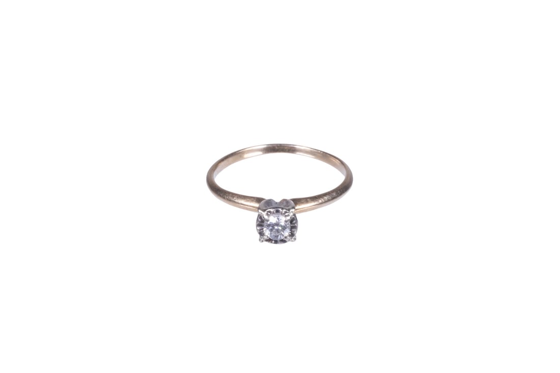 VINTAGE 14K GOLD AND DIAMOND RING: VINTAGE 14K GOLD AND DIAMOND RINGA vintage 14K gold ring set with a single round diamond, approx. 0.10 ct. in a white gold prong setting, atop a slender yellow gold band. Stamped. 0.8 dwt. tw.Ring Siz