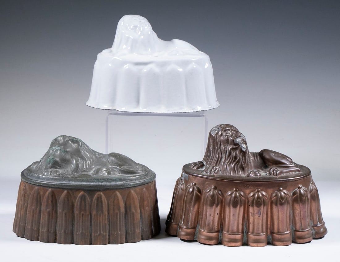 (3) LION FORM JELLY MOLDS: (3) LION FORM JELLY MOLDS (3) Vintage Figural Oval Metal Food Molds, all topped with lions, including: Copper mold, stamped "57 ?/4", with fluted sides, 5" high, 7 1/2" x 4 1/2", soldered repairs;