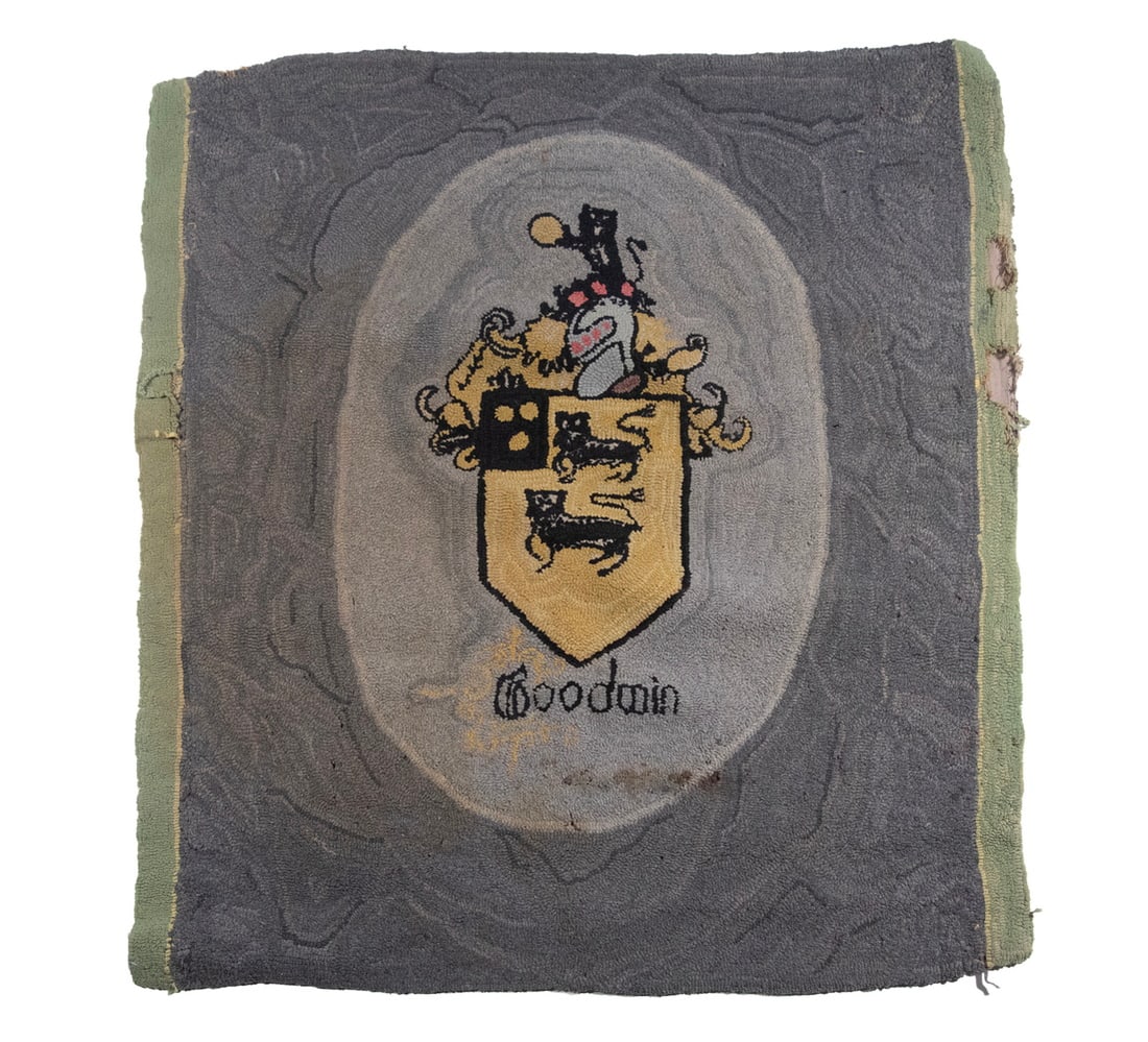 HOOKED RUG GOODWIN FAMILY CREST: HOOKED RUG GOODWIN FAMILY CREST Circa 1920's, came with Higgins stair runner, probably Mrs. Higgins' maiden name. Gray field. Stained, edge losses. Size: 33 x 29 in. (83.8 x 73.7 cm.)