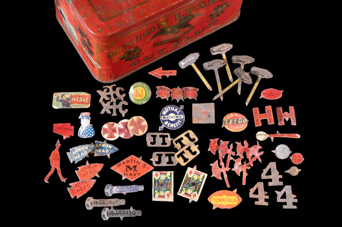 (54) ANTIQUE TOBACCO TIN TAGS WITH BOX, 29 VARIETIES: (54) ANTIQUE TOBACCO TIN TAGS WITH BOX, 29 VARIETIES A diverse group of 54 original tin tags representing 28 different tobacco brands, notable for their colorful lithographed surfaces and inventive