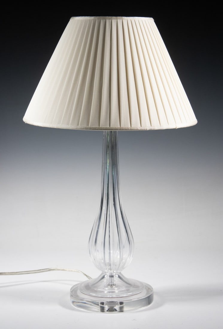 VINTAGE CRYSTAL GLASS TABLE LAMP WITH PLEATED SHADE: VINTAGE CRYSTAL GLASS TABLE LAMP WITH PLEATED SHADE A clear crystal glass table lamp with a fluted baluster-form body on a circular base, fitted with a pleated fabric shade. Provenance: Dorothy S.