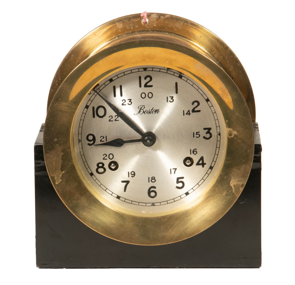 "BOSTON" SHIP'S BELL CLOCK BY CHELSEA: "BOSTON" SHIP'S BELL CLOCK BY CHELSEA Mid-20th c. Brass Cased Ship's Clock by the Chelsea Clock Co., with key, silvered dial, ship's bell striking. With ebonized wooden stand. Size: 6 1/4 x 3 1/2 x 6 