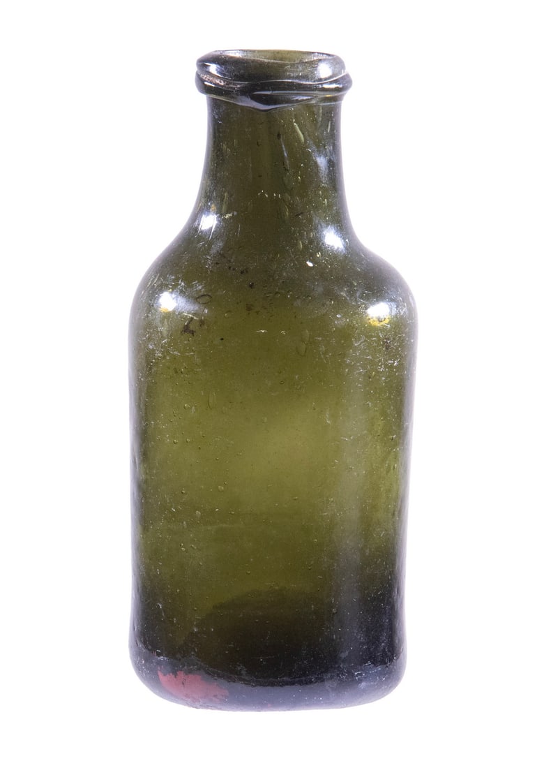 18TH C. DARK GREEN GLASS UTILITY BOTTLE: 18TH C. DARK GREEN GLASS UTILITY BOTTLE Early Blown "Black" Glass Bottle or Jar, likely European origin, with kick-up base, applied rim. Size: 8 x 3 1/2 x 3 1/2 in. (20.3 x 8.9 x 8.9 cm.)
