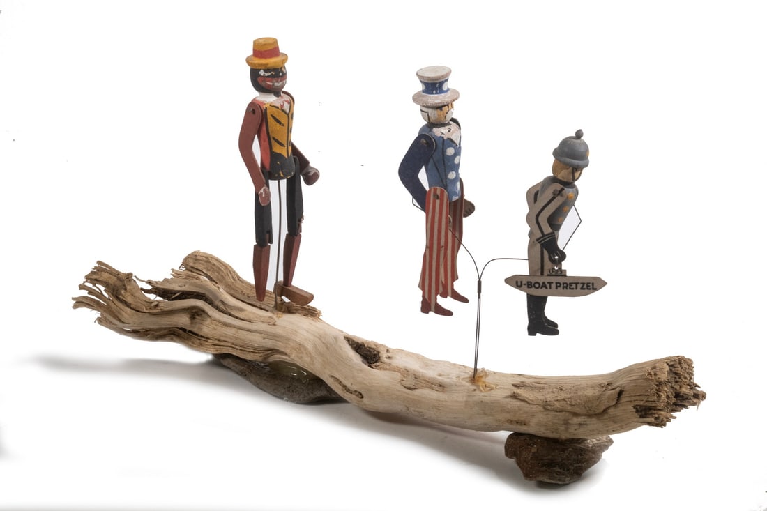 AMERICAN FOLK ART WWI ERA DANCING FIGURE TOY: AMERICAN FOLK ART WWI ERA DANCING FIGURE TOY Figures of a Black Dandy, Uncle Sam and Kaiser Wilhelm with a "U Boat Pretzel", in carved and painted wood with tin jointed limbs, mounted by wires to a