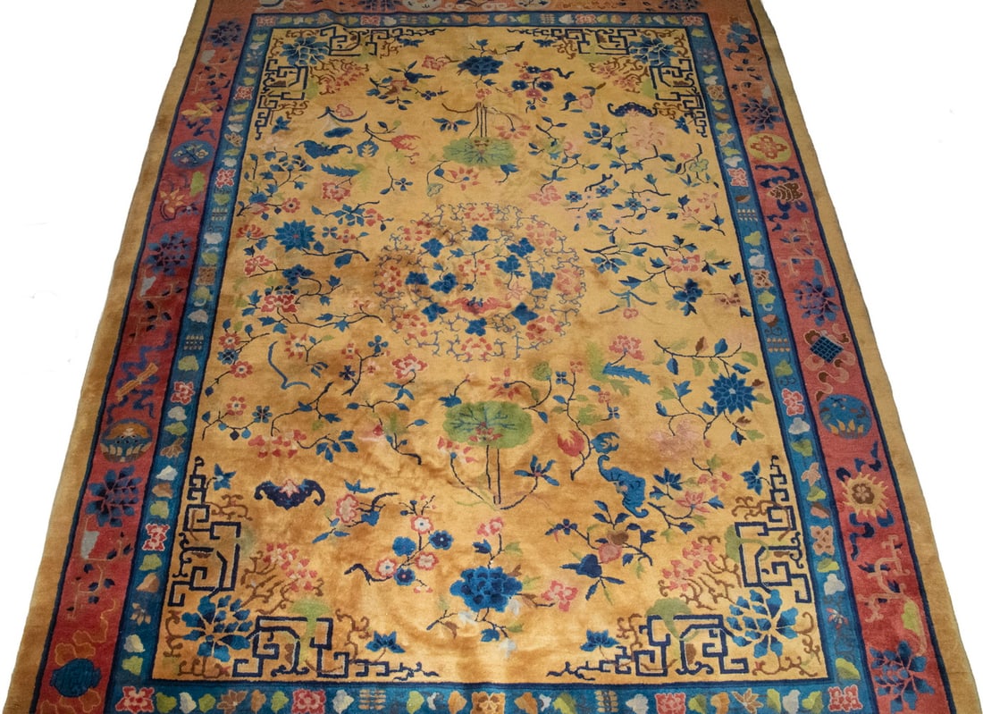 LARGE CHINESE RUG: LARGE CHINESE RUG Decorated with a central medallion amidst scrolling floral vines and stylized peony blossoms, with bats and auspicious motifs throughout, within a contrasting border of key-fret and