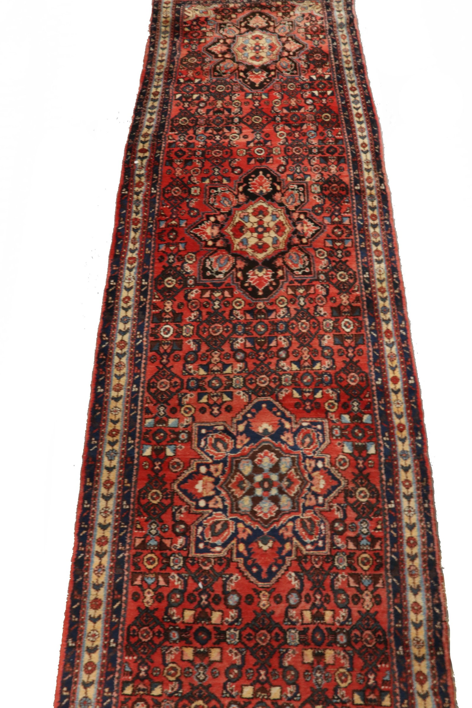 HAMADAN CORRIDOR RUG (3' 10" x 17' 10"): HAMADAN CORRIDOR RUG (3' 10" x 17' 10") Northwest Persia, second quarter 20th c., a column of five rosette medallions in midnight blue, sky blue and gold on a densely filled tomato red field, with