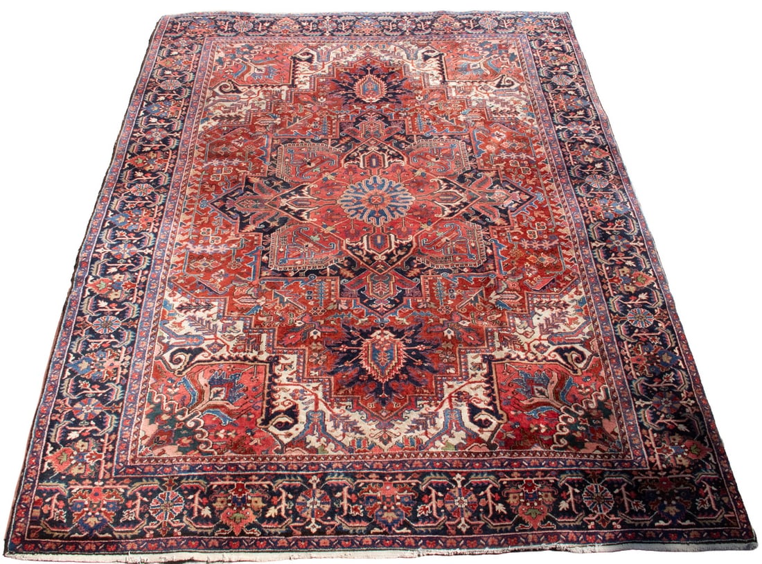 HERIZ CARPET(12'4" x 9'10"): HERIZ CARPET(12'4" x 9'10") An offering of a vintage Heriz pattern rug with a coarser, Gorevan style weave pattern. Features a geometric medallion on a red field with designs of palmettes and vines