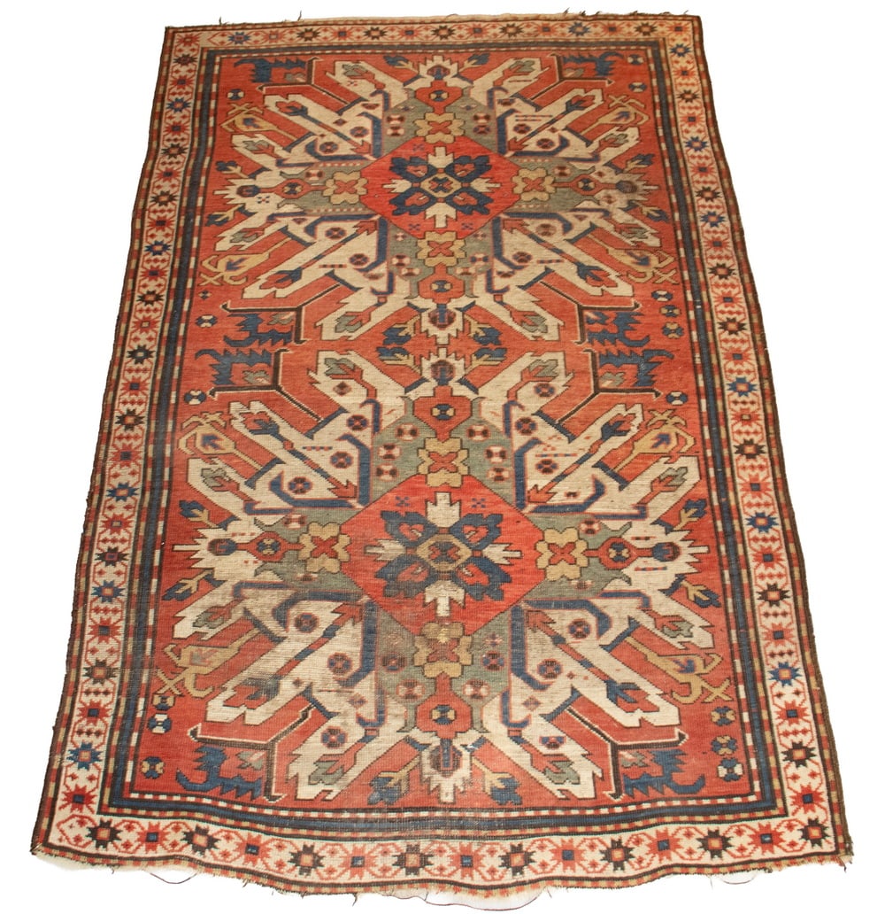 ANTIQUE KAZAK CAUCASIAN RUG (4'8" x 7'2"): ANTIQUE KAZAK CAUCASIAN RUG (4'8" x 7'2") Two Medallion in typical palette of brick red, with dark and pale blue, ochre and white geometry, fringed ends, early 20th century. Some wear, edge loss.