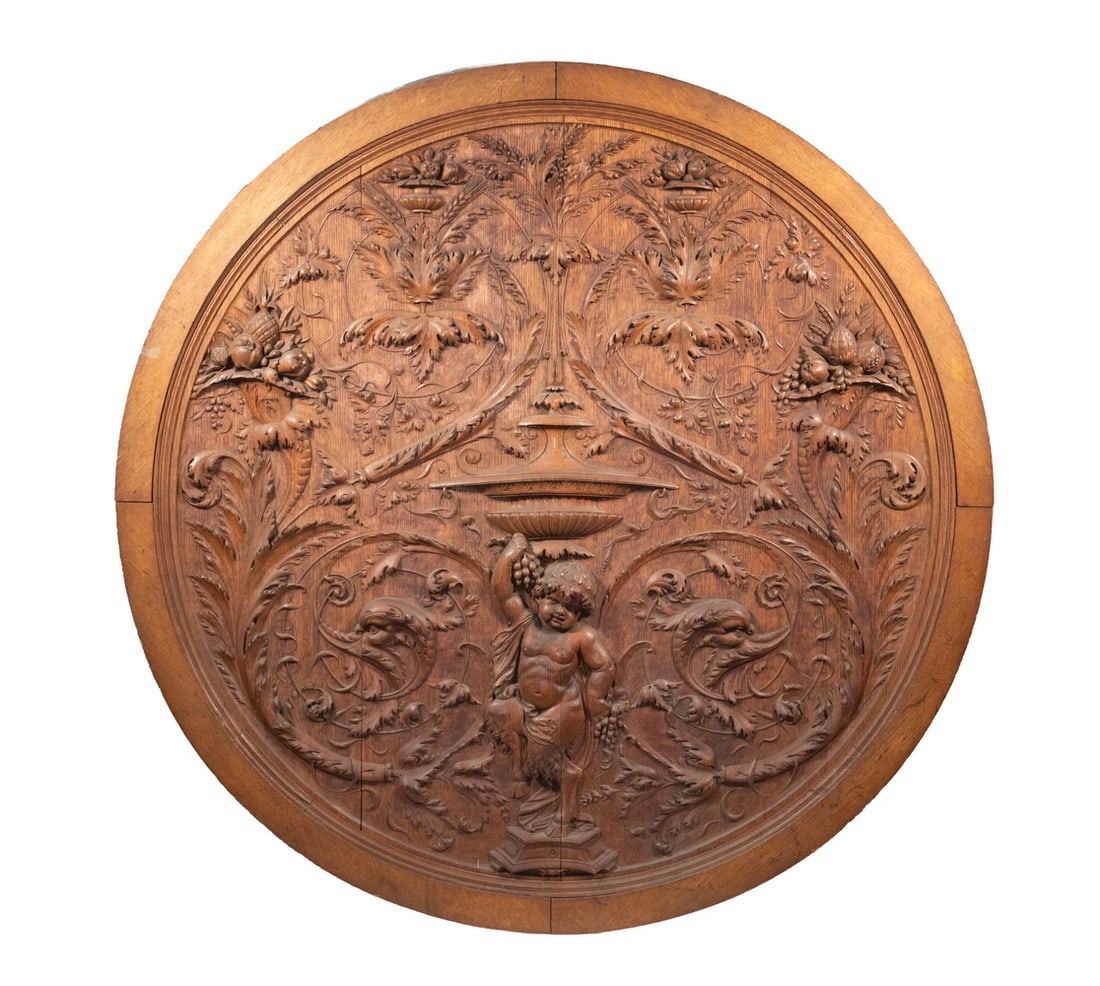 CIRCA 1880 LARGE GOLDEN OAK ARCHITECTURAL RONDEL: CIRCA 1880 LARGE GOLDEN OAK ARCHITECTURAL RONDEL American Neo-Classical Round Panel with relief carvings of a Cherub flanked by Dolphins at foot of a fountain, set within a garden of vine acanthus