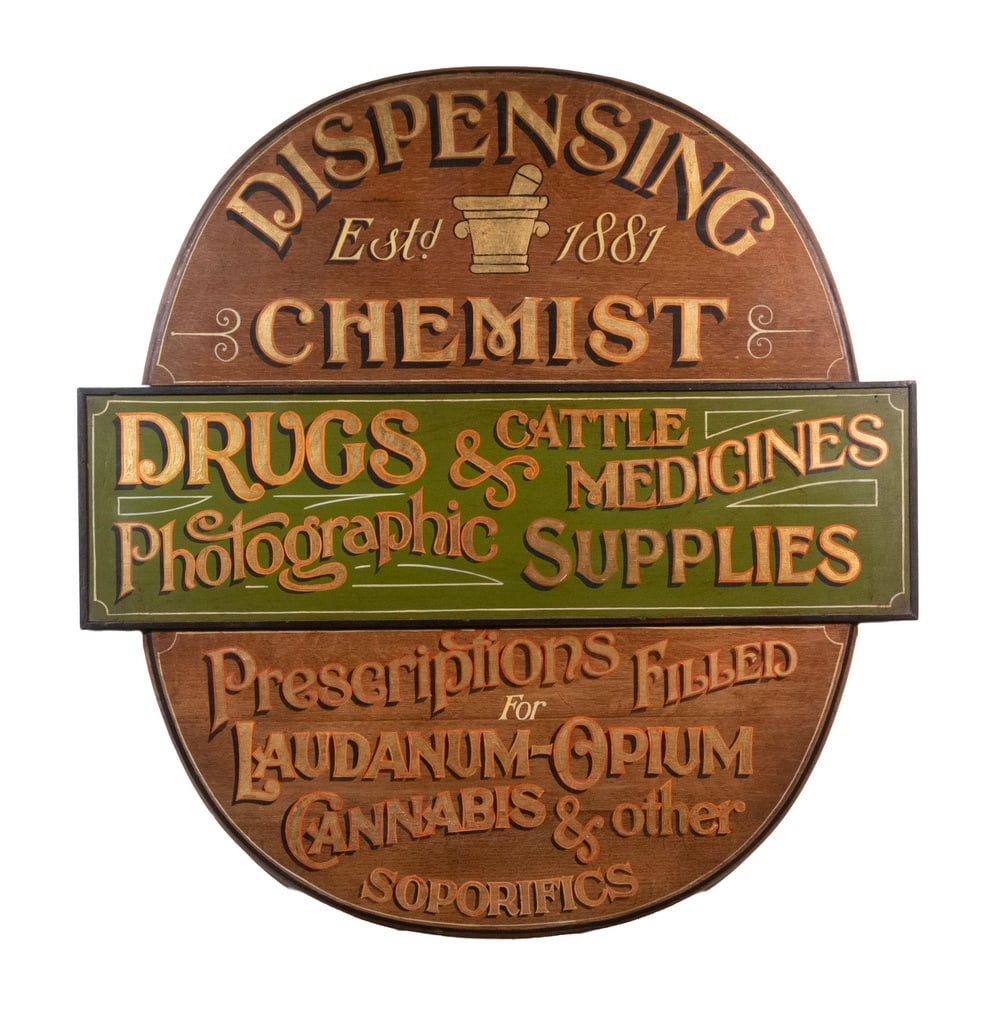 BRITISH PHARMACY TRADE SIGN: BRITISH PHARMACY TRADE SIGN "Dispensing Chemist, Estd. 1881, Drugs & Cattle Medicines, Photographic Supplies, Prescriptions Filed for Laudinum-Opium, Cannabis & Other Soporifics", oil on mahogany