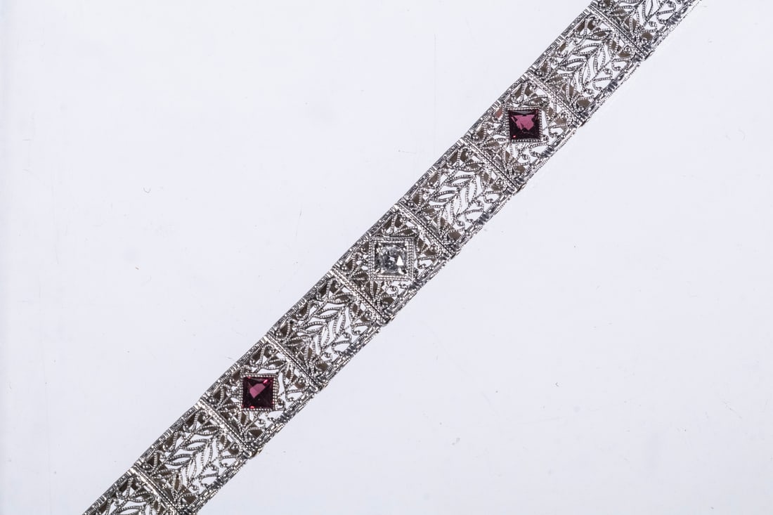 EDWARDIAN 14K WHITE GOLD, DIAMOND AND TOURMALINE FILIGREE BRACELET: EDWARDIAN 14K WHITE GOLD, DIAMOND AND TOURMALINE FILIGREE BRACELET An elegant Edwardian bracelet in 14K white gold, designed with finely pierced filigree panels featuring repeating foliate motifs. Set