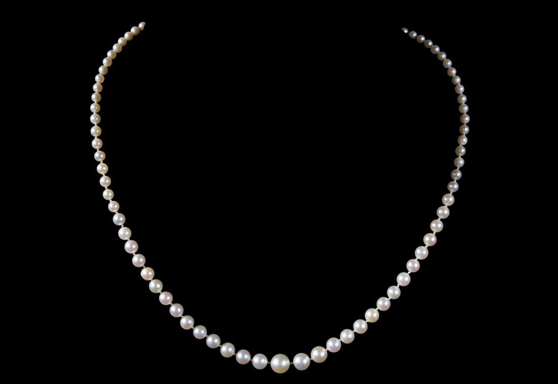 GRADUATED PEARL NECKLACE: GRADUATED PEARL NECKLACE A graduated strand of cultured pearls, measuring approximately 3.46 mm to 8.65 mm, exhibiting soft luster and subtle variation in tone. Completed with a 14K white gold clasp