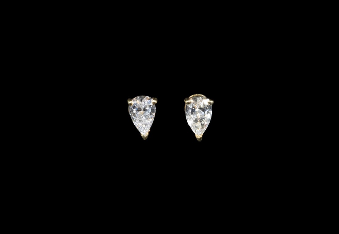 PR 18K GOLD PEAR-SHAPED DIAMOND STUD EARRINGS: PR 18K GOLD PEAR-SHAPED DIAMOND STUD EARRINGS A pair of 18K yellow gold stud earrings, each set with a pear-shaped diamond measuring approximately 7.06 x 4.77 mm, mounted in three-prong settings. The 