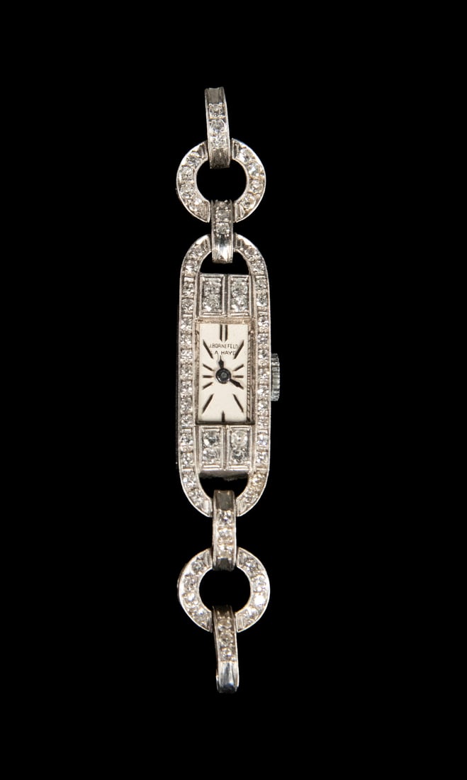 ART DECO PLATINUM AND DIAMOND WOMEN'S WRISTWATCH: ART DECO PLATINUM AND DIAMOND WOMEN'S WRISTWATCH An Art Deco platinum women's wristwatch featuring an elongated case with geometric openwork links and fine milgrain detailing. The case and bracelet