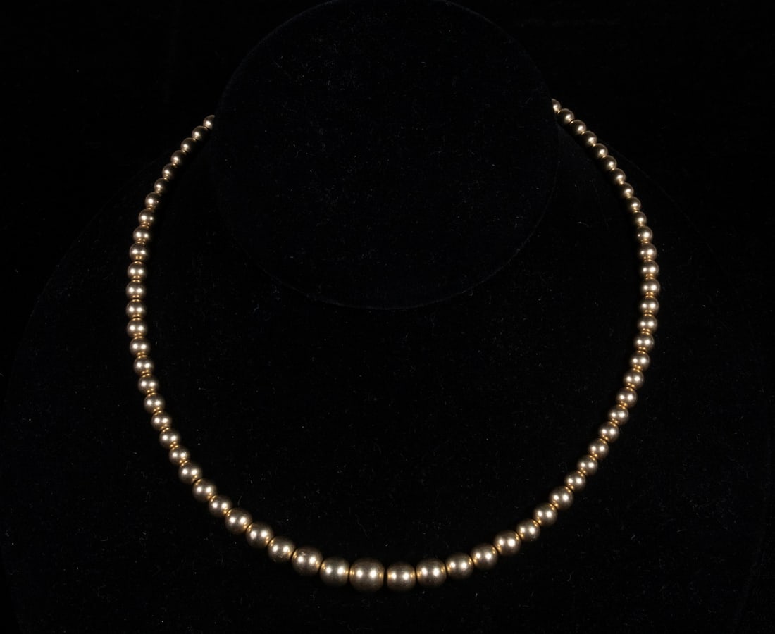 VINTAGE 14K YELLOW GOLD BEAD NECKLACE: VINTAGE 14K YELLOW GOLD BEAD NECKLACE A graduated 14K yellow gold bead necklace composed of polished round beads, largest at center, tapering toward the clasp. Secured with a spring-ring closure. 8.9 