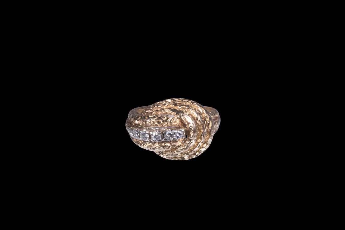 14K YELLOW GOLD TEXTURED RING WITH DIAMOND: 14K YELLOW GOLD TEXTURED RING WITH DIAMOND A sculptural 14K yellow gold ring featuring a raised, rope-textured design, centered with a vertical row of (6) round-cut diamonds. 5.1 dwt. tw. With crack