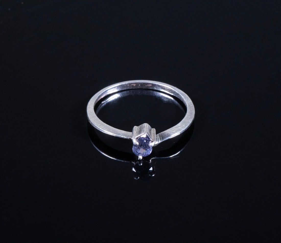 STERLING SILVER RING WITH 0.60 CT CERTIFIED NATURAL PURPLE SPINEL: STERLING SILVER RING WITH 0.60 CT CERTIFIED NATURAL PURPLE SPINEL A petite yet vivid natural spinel weighing 0.60 carats is mounted in a minimalist sterling silver setting. The gem is pear-shaped, bri