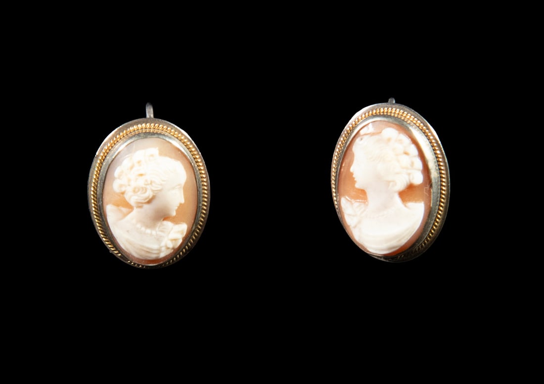 PR VICTORIAN SILVER SHELL CAMEO EARRINGS: PR VICTORIAN SILVER SHELL CAMEO EARRINGS A pair of oval shell cameo earrings depicting classical female profiles, each carved in relief against a warm peach-toned ground. Set in silver mounts with twi