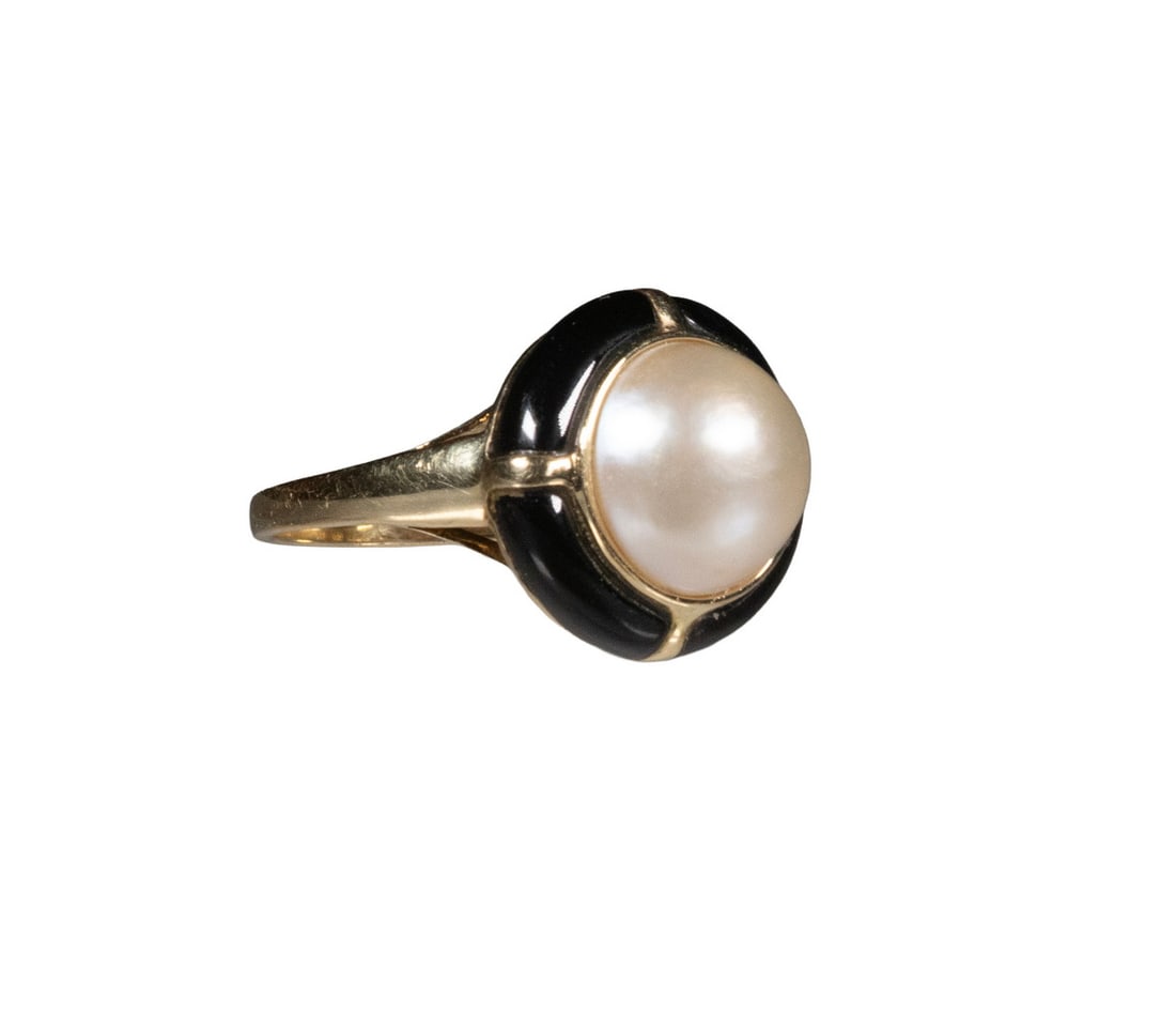 14K GOLD MABE PEARL AND ONYX RING: 14K GOLD MABE PEARL AND ONYX RING Centering a mabe pearl measuring approximately 11.47 mm in diameter, displaying a creamy white body color with strong orient and luster, framed by polished black onyx