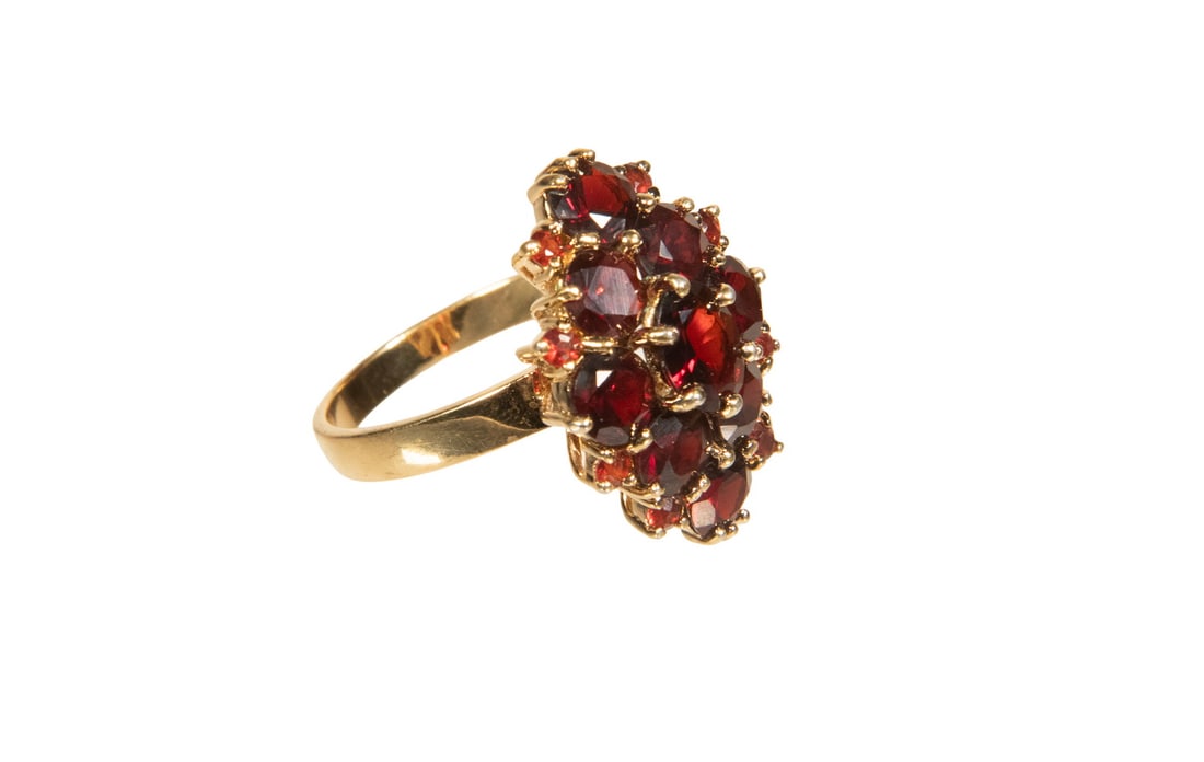 14K GOLD GARNET CLUSTER RING: 14K GOLD GARNET CLUSTER RING A traditional floral cluster ring featuring a center oval cut and (16) round-cut garnets of rich deep burgundy-red color, mounted in 14K gold with a raised gallery in a ti