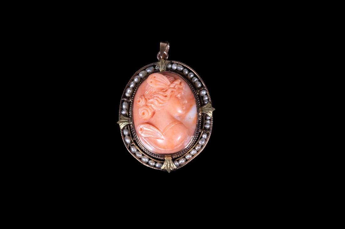VICTORIAN 14K GOLD CORAL CAMEO BROOCH/PENDANT: VICTORIAN 14K GOLD CORAL CAMEO BROOCH/PENDANT An oval carved coral cameo depicting a classical female profile in relief, measuring approximately 24.77 x 19.29 mm, set within a 14K yellow and rose gold