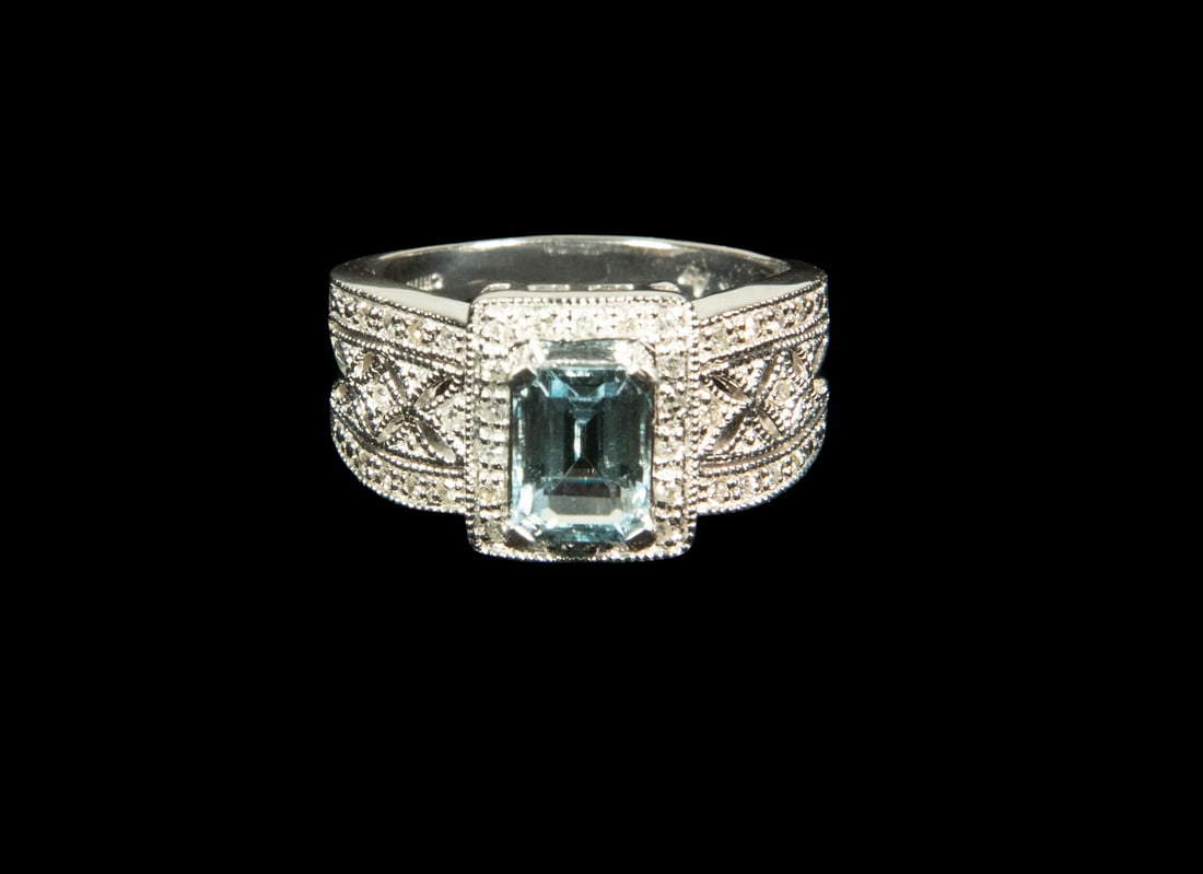 14K GOLD AQUAMARINE AND DIAMOND RING: 14K GOLD AQUAMARINE AND DIAMOND RING Set with an emerald-cut aquamarine measuring approximately 8.04 x 5.97 mm, framed by (38) melee diamonds in a square halo. The shoulders feature pierced geometric 