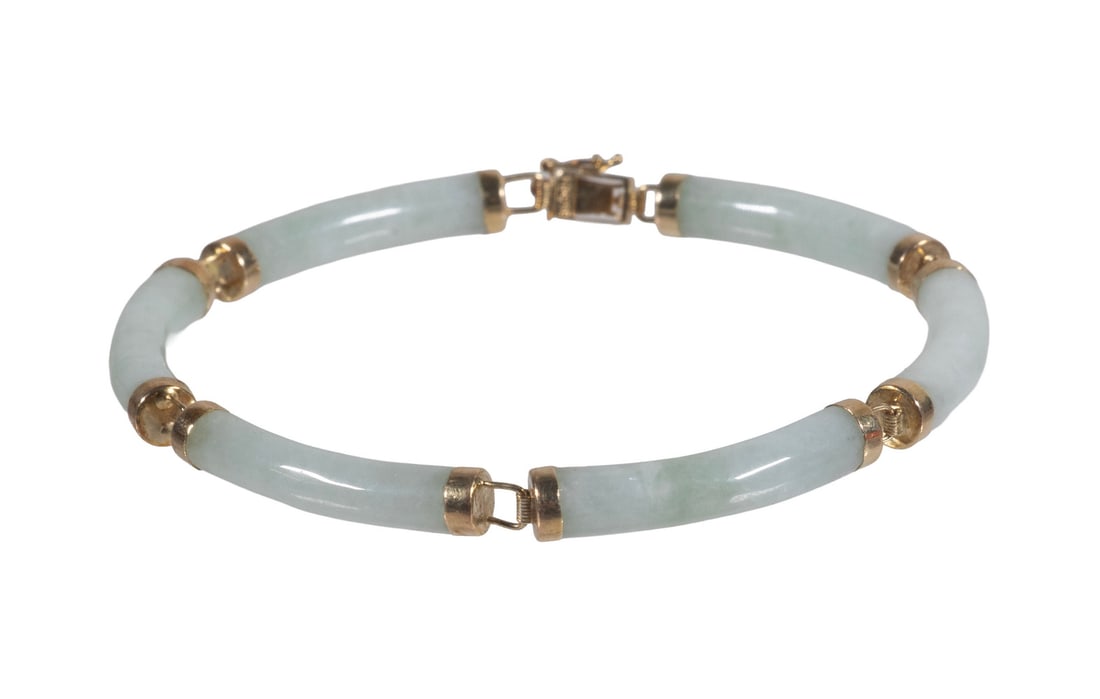 VINTAGE 14K GOLD AND JADE LINK BRACELET: VINTAGE 14K GOLD AND JADE LINK BRACELET A refined bracelet composed of (6) curved pale green jade segments joined by polished 14K yellow gold mounts and links. The bracelet features a delicate articul