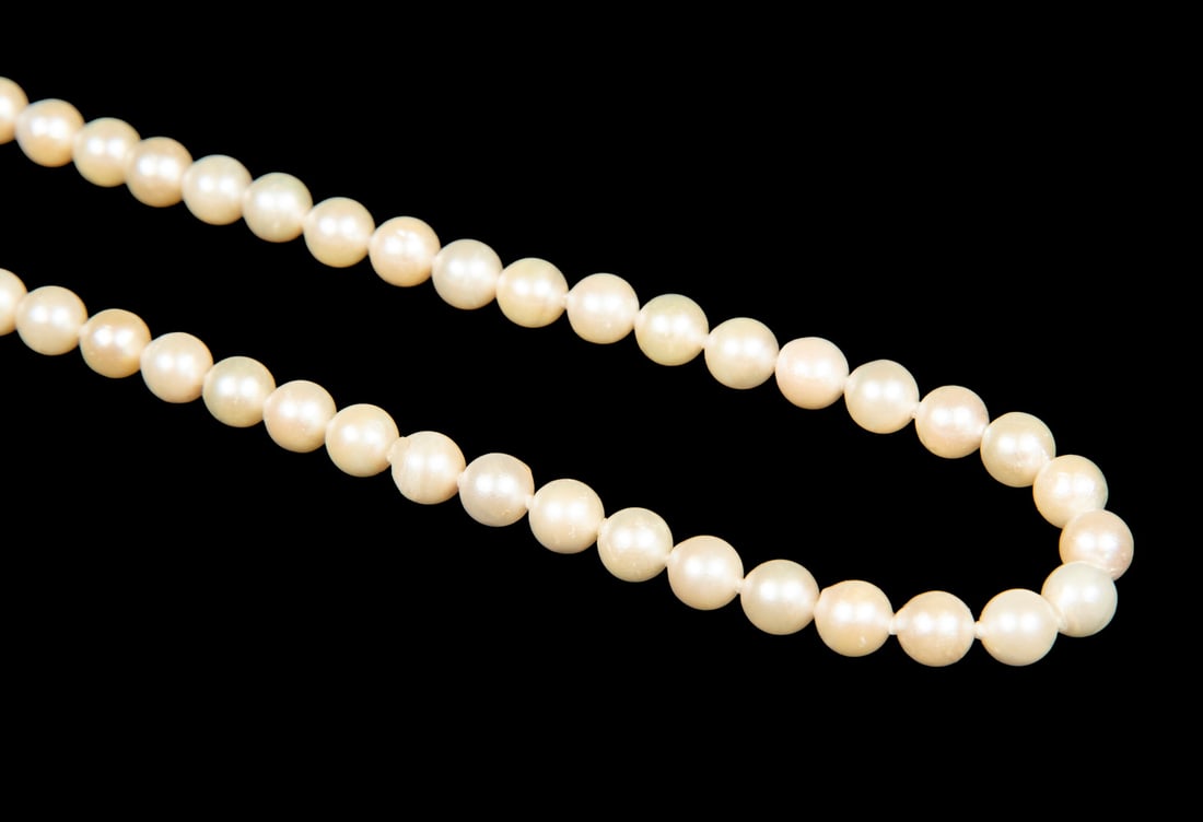 VINTAGE PEARL NECKLACE: VINTAGE PEARL NECKLACE A single strand of cultured pearls, composed of well-matched round pearls measuring approximately 6.0 mm in diameter, completed with a 14K gold clasp, stamped. The pearls displa