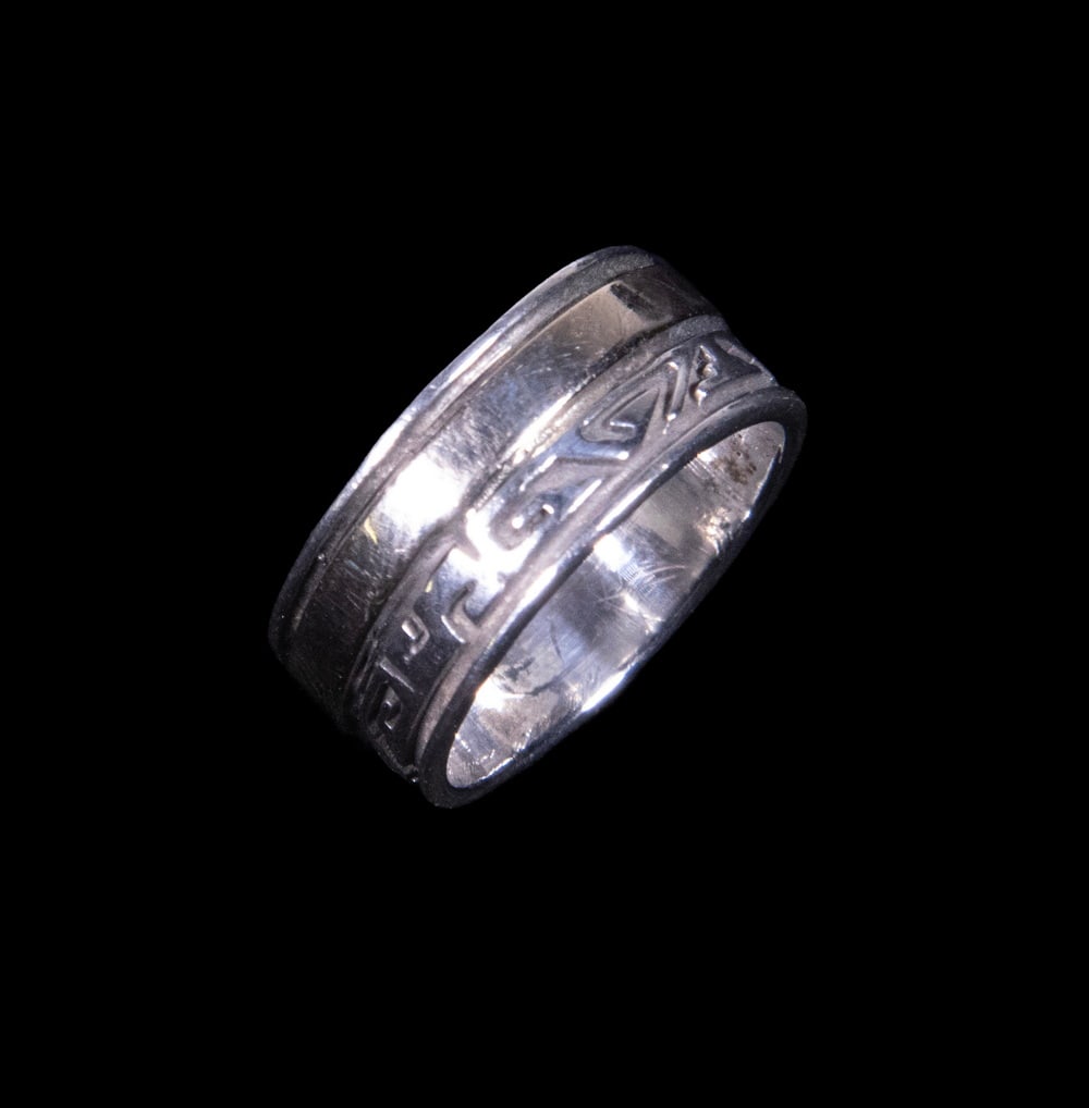14K GOLD BAND RING WITH GREEK KEY MOTIF: 14K GOLD BAND RING WITH GREEK KEY MOTIF A 14K white gold band ring of broad form, decorated with a continuous Greek key motif. The design is framed by polished borders, giving the ring a clean and arc