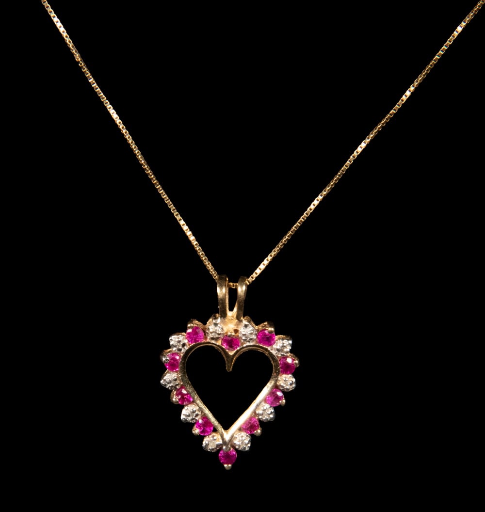 14K GOLD SPINEL AND DIAMOND HEART PENDANT NECKLACE: 14K GOLD SPINEL AND DIAMOND HEART PENDANT NECKLACE A 14K yellow gold pendant in an open heart design, set with ten round-cut pink spinels alternating with ten round diamond melees. The diamonds are mo