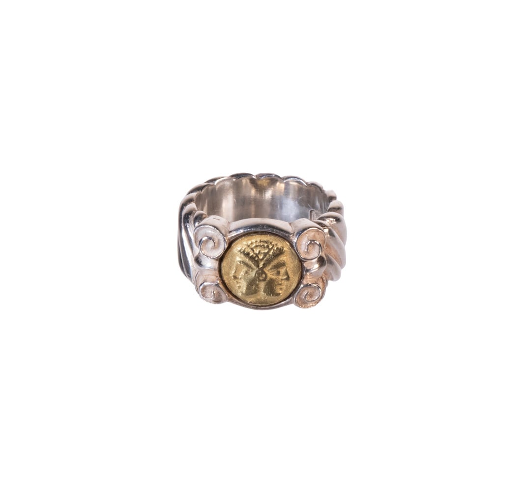 DESIGNER STERLING SILVER AND 18K GOLD COIN MOTIF RING: DESIGNER STERLING SILVER AND 18K GOLD COIN MOTIF RING A bold sterling silver ring set with a central 18K yellow gold coin-style medallion depicting a stylized profile within a circular bezel, framed