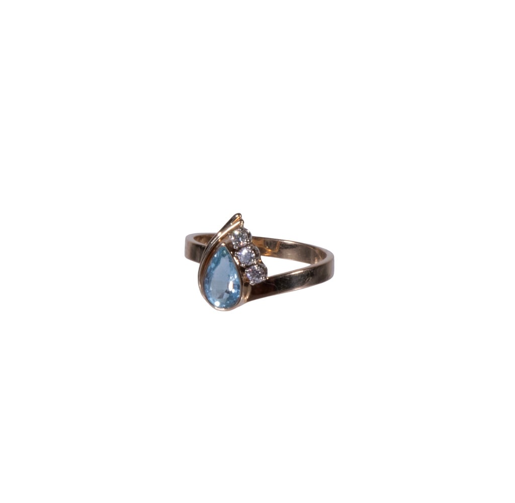 VINTAGE 14K GOLD AND AQUAMARINE RING: VINTAGE 14K GOLD AND AQUAMARINE RING A vintage yellow gold ring set with a pear-shaped faceted blue aquamarine (8mm x 5.5 mm), flanked by (3) small round diamond accents in a 14K gold mount, stamped. 
