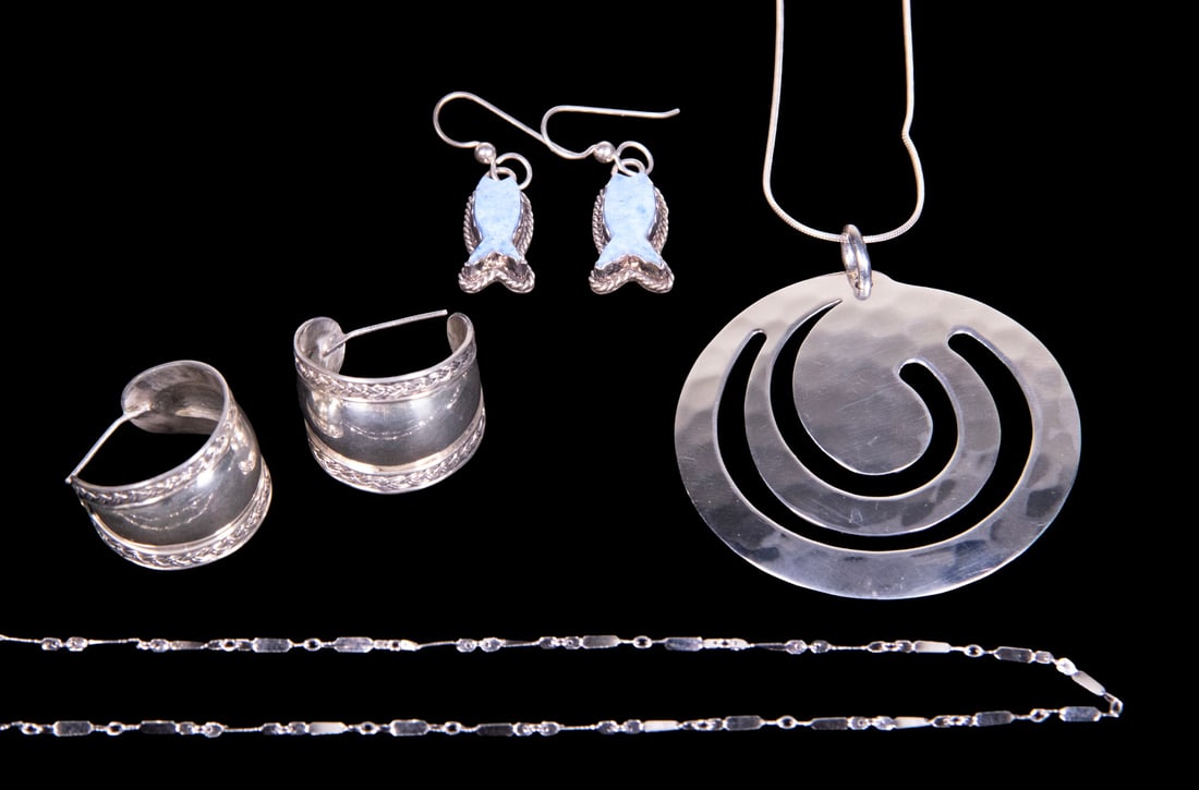 (4) VINTAGE STERLING SILVER JEWELRY: (4) VINTAGE STERLING SILVER JEWELRY A group of sterling silver jewelry comprising a hammered circular pendant necklace; a silver link chain; a pair of drop earrings set with blue stones; and a pair of