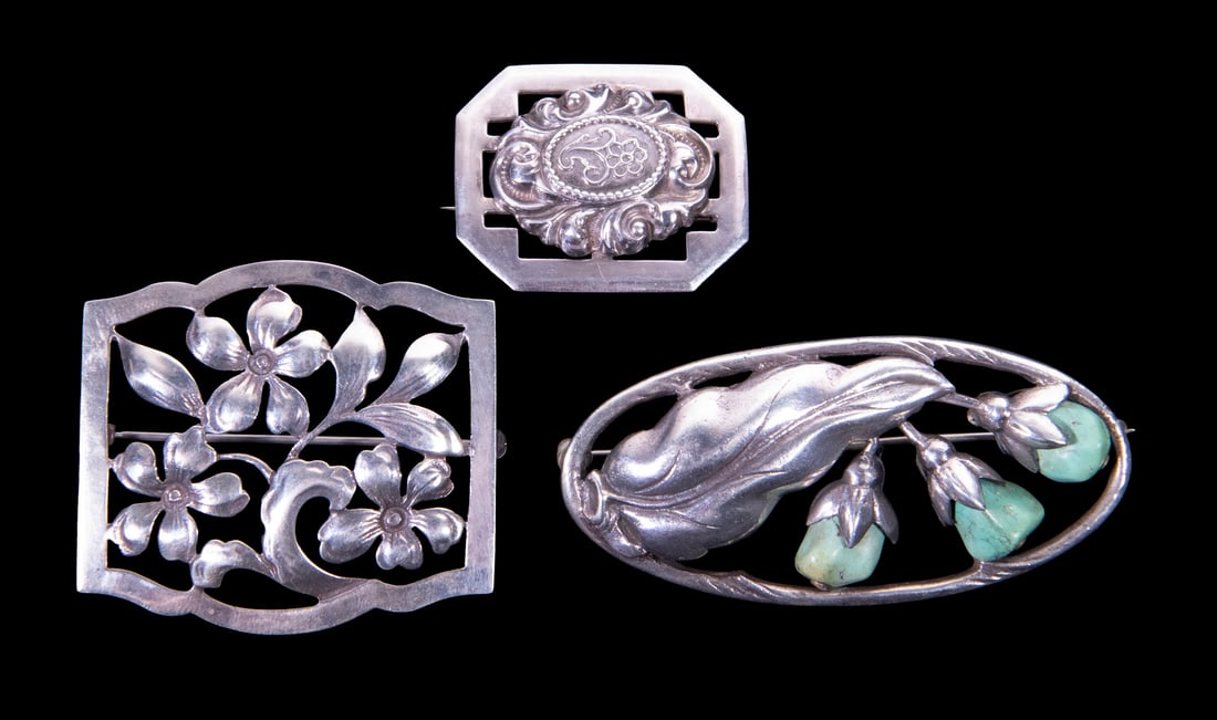 (3) ART NOUVEAU REVIVAL STERLING SILVER BROOCHES: (3) ART NOUVEAU REVIVAL STERLING SILVER BROOCHES A group of three sterling silver brooches in varied decorative styles, including a floral openwork brooch, an oval brooch featuring a stylized floral m