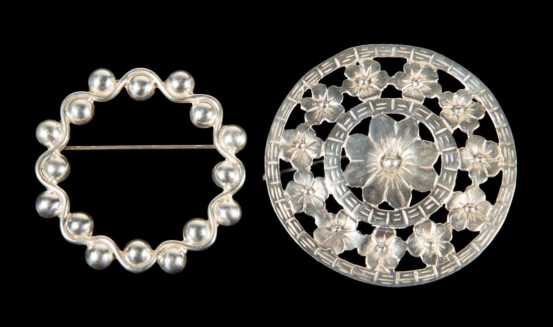 (2) VINTAGE STERLING SILVER BROOCHES: (2) VINTAGE STERLING SILVER BROOCHES Including a circular sterling silver floral brooch with openwork design featuring layered blossoms within concentric pierced borders, and a Mexican Taxco sterling 