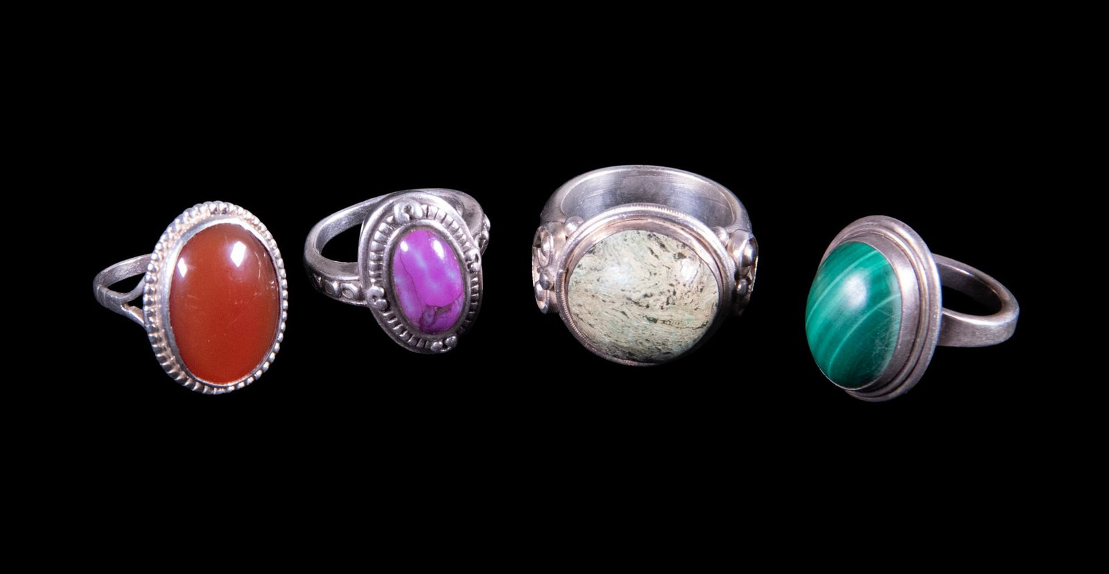 (4) STERLING SILVER RINGS WITH VARIOUS STONES: (4) STERLING SILVER RINGS WITH VARIOUS STONES A group of four sterling silver rings, each with decorative mounts, set with a mottled green hardstone cabochon, likely serpentine; a banded malachite