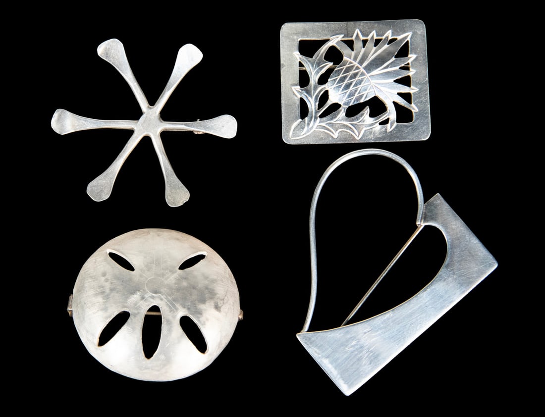 (4) VINTAGE STERLING SILVER BROOCHES: (4) VINTAGE STERLING SILVER BROOCHES Including a pierced thistle-form brooch, a modernist geometric brooch, a domed abstract brooch with openwork decoration, and a six-pointed abstract star-form