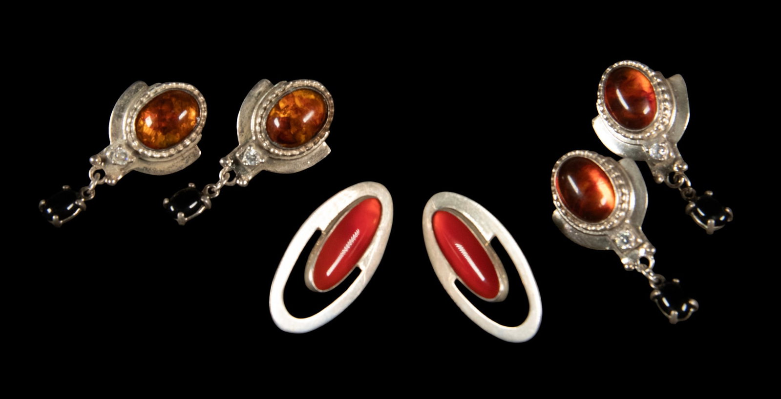 (3) PR STERLING SILVER AMBER AND CARNELIAN EARRINGS: (3) PR STERLING SILVER AMBER AND CARNELIAN EARRINGS A group of three pairs of earrings, including two matching pairs with amber and onyx and a pair of modernist ear studs set with vertical oval