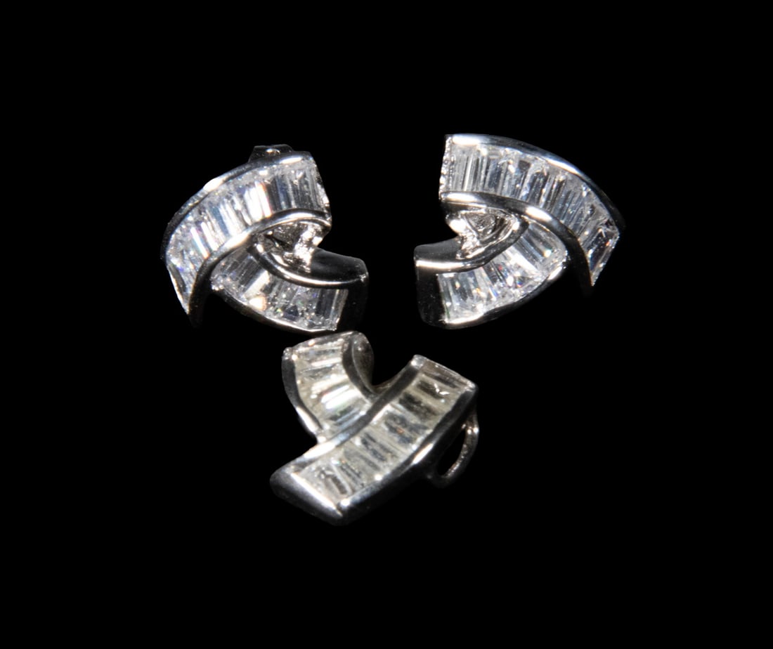 (3) STERLING SILVER AND CUBIC ZIRCONIA EARRINGS AND PENDANT SET: (3) STERLING SILVER AND CUBIC ZIRCONIA EARRINGS AND PENDANT SET A three-piece set including a pair of sterling silver earrings and a matching pendant, each designed with overlapping ribbon-like forms