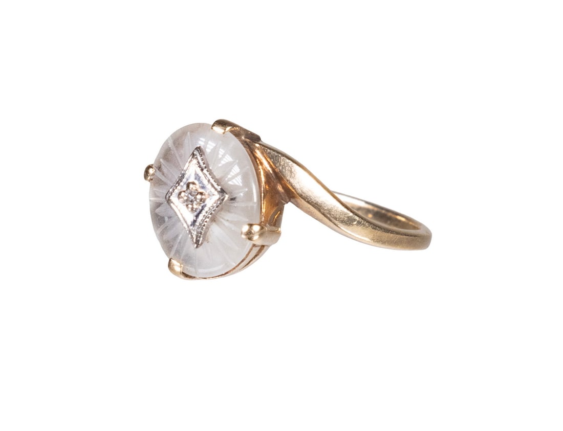 10K GOLD RING WITH CARVED ROCK CRYSTAL AND DIAMOND ACCENT: 10K GOLD RING WITH CARVED ROCK CRYSTAL AND DIAMOND ACCENT A gold ring featuring a matte-finished carved rock crystal panel, centered with a white gold inset set with a single melee diamond. The