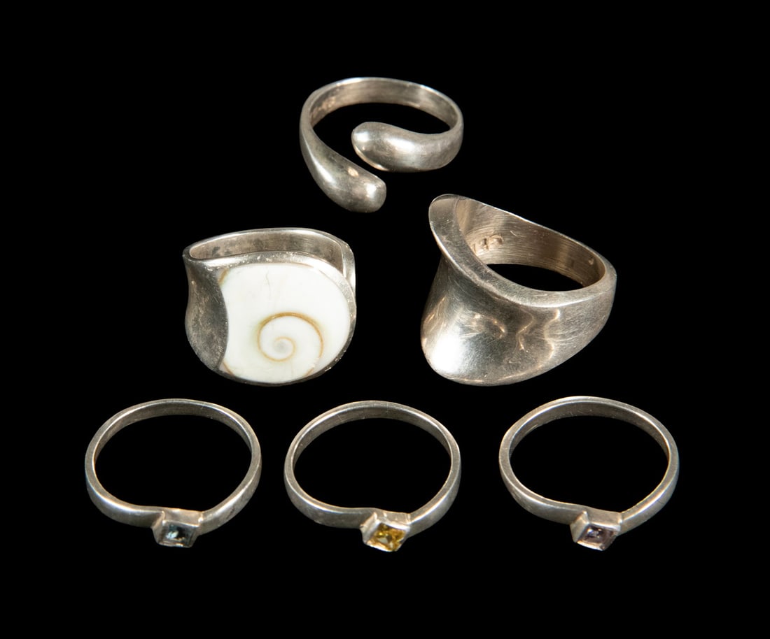 (6) MODERN STERLING SILVER RINGS: (6) MODERN STERLING SILVER RINGS A group of six studio design modern sterling silver rings. Three rings are bezel set with colored glass stones; one is inlayed with a fossil shell and two are just