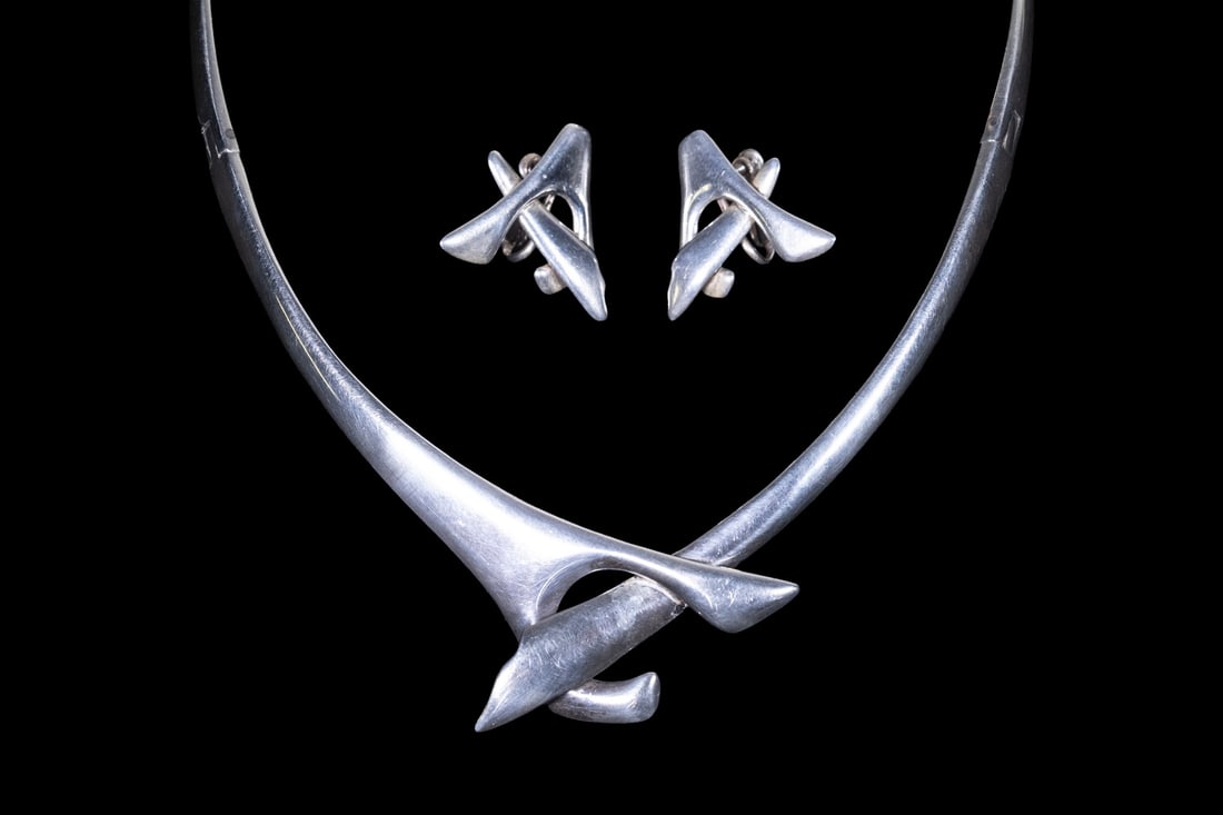(2 PCS) SIGI PINEDA MEXICAN TAXCO STERLING SILVER SUITE: (2 PCS) SIGI PINEDA MEXICAN TAXCO STERLING SILVER SUITE A sculptural modernist sterling silver jewelry suite by Sigi Pineda, Taxco, comprising a torque necklace and a pair of matching clip earrings.